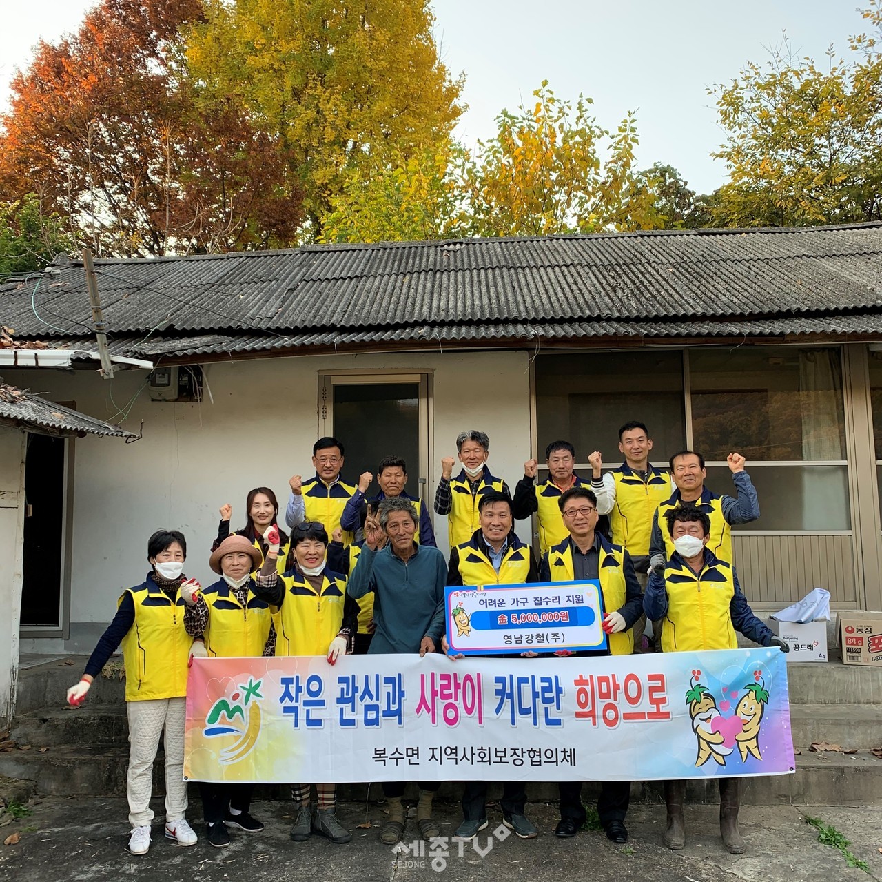 19일 복수면지역사회보장협의체 위원들이 대상자의 집에서 집수리 지원을 하며 기념사진을 찍고 있다.(사진제공=금산군청)