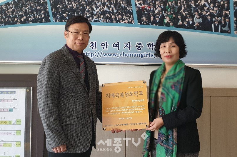 천안시동남구치매안심센터가 12일 천안여자중학교를 치매극복 선도학교로 지정하고 현판을 전달하고 있다.(사진제공=천안시청)