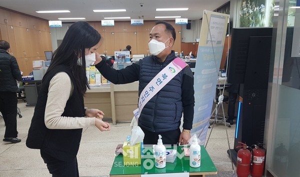 천안시 북면 주민자치위원회가 북면 행정복지센터를 방문하는 주민들을 대상으로 발열체크, 마스크 착용 권유, 손세정제 사용 독려 등 봉사를 실시하고 있다.(사진제공=천안시청)