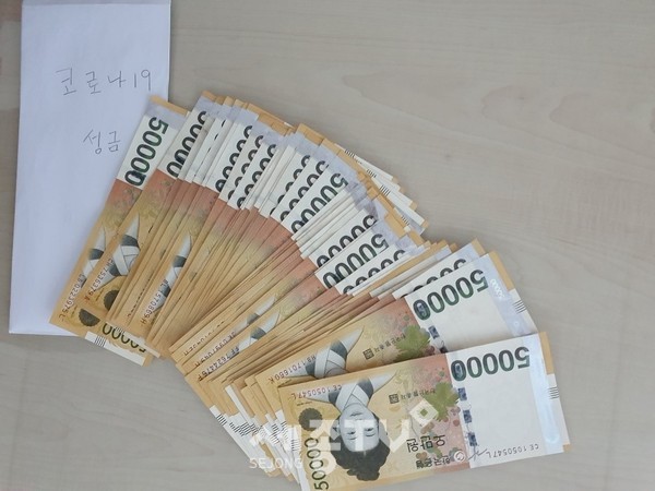 신안동 거주 주민(유00, 78세)이 코로나19 확산으로 어려움을 겪고 있는 이웃들에게 전달해달라며 기부한 후원금 200만원 모습. (사진제공=천안시청)