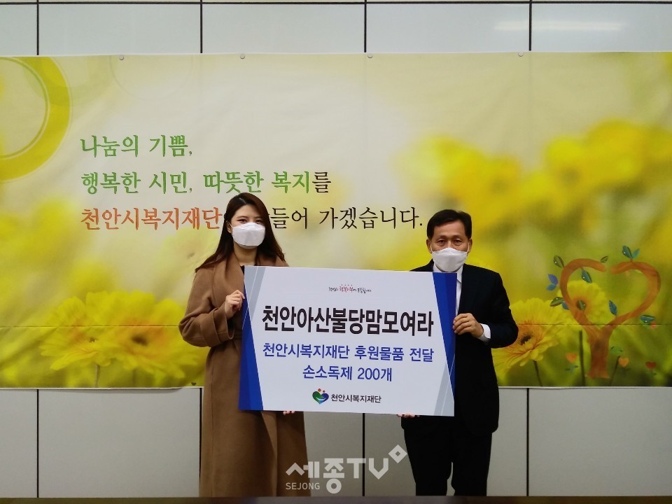 육아 온라인 커뮤니티 천안아산불당맘모여라가 지난 17일 손소독제 200개를 천안시복지재단에 전달했다. (왼쪽부터 한아름 카페지기, 최창호 천안시복지재단상임이사) 사진제공=천안시청