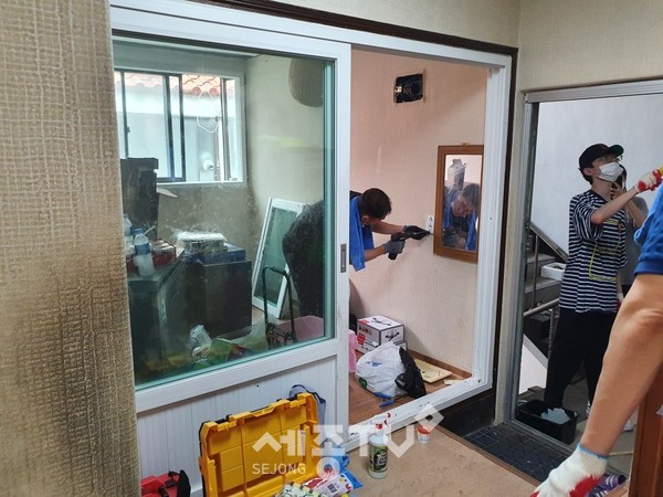 쌍용100인회 회원과 자녀 40여명이 지난 27일 홀로 사는 노인 가정의 주거환경을 개선하고 있다.(사진제공=천안시청)