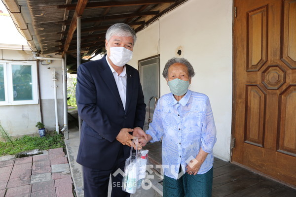 문정우 금산군수가 어르신에게 마스크를 전달하며 손을 맞잡고 있다.