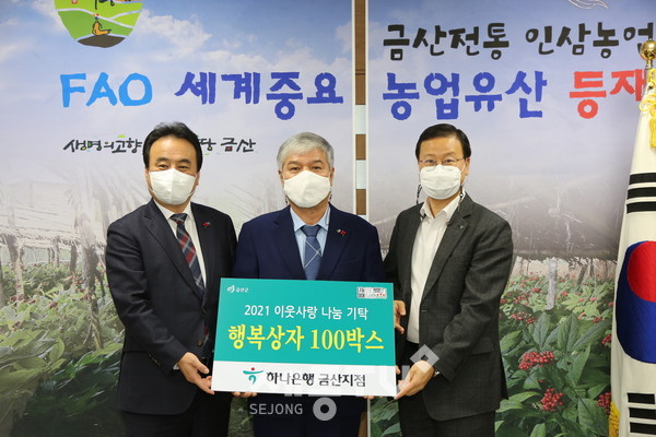 하나은행 충남북영업본부 이성진 지역대표(왼쪽)와 하나은행 금산지점 임창묵 지점장(오른쪽)이 물품을 기탁하고 문정우 금산군수(중간)와 기념사진을 찍고 있다.(사진제공=금산군청)