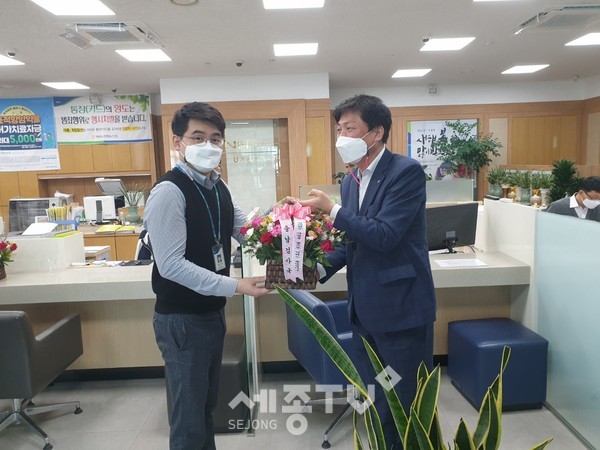 농협충남검사국 김용철 국장(오른쪽)이 종합감사기간 중 계룡농협 직원에게 꽃바구니를 전달하고 있다.(농협 충남검사국)