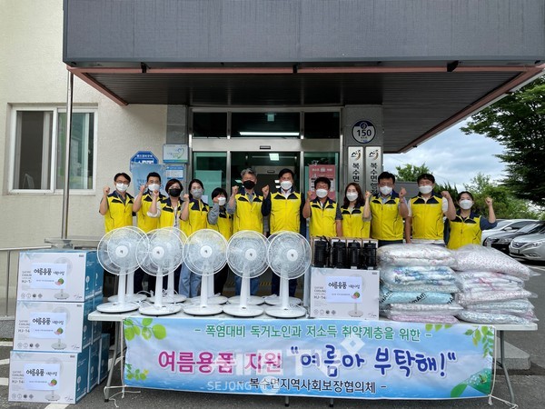 복수면지역사회보장협의체 위원들이 준비한 여름용품 앞에서 기념사진을 찍고 있다.(사진=금산군)