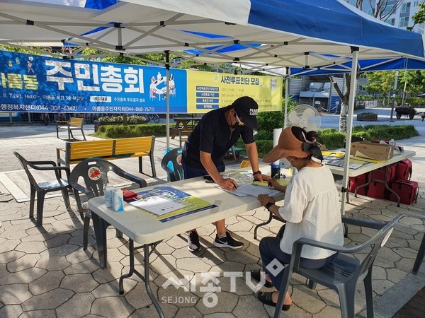 아름동 주민자치회가 달빛광장에서 주민들을 대상으로 마을사업 설명과 사전투표인단 모집을 안내하고 있다.(사진=세종시청 제공)