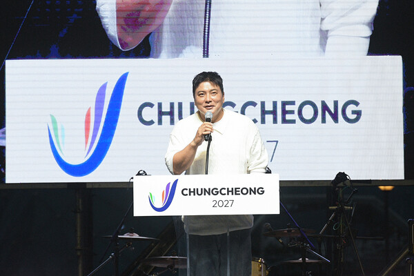 흥이나유 페스티벌에서 대회기 전달을 받아 강창희 조직위원장이 깃발을 흔들고 있다./사진제공=2027 충청 유니버시아드대회 조직위원회