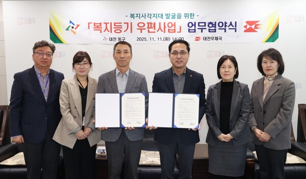 박희조 동구청장(가운데 오른쪽)과 선우환 대전우체국장(가운데 왼쪽)이 복지등기우편사업 업무협약을 체결한 뒤 기념촬영을 하고 있다./사진제공=대전 동구청